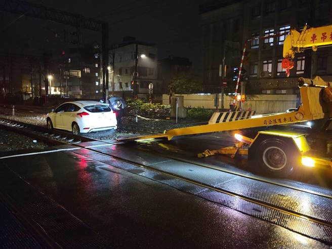 新北市瑞芳区一坑路平交道15日凌晨有一部自小客车停在铁轨的道碴上，民眾通报警方赶到现场拖离。（翻摄照片／张志康新北传真）