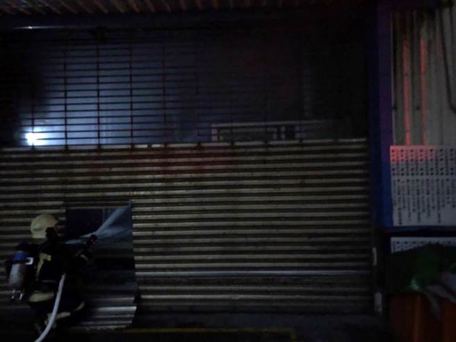 消防人員切鐵門布水線灌救。（翻攝畫面／蔡明亘桃園傳真）
