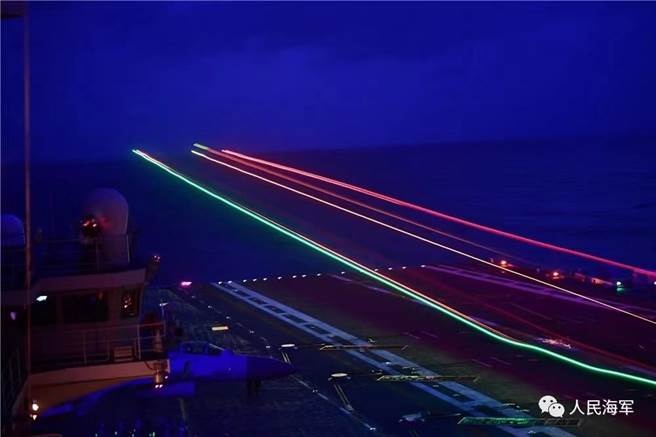 中共海軍航母山東艦在南海開展實戰化演練，戰機夜間起飛在慢快門下拉出光影線條。（圖／中共解放軍海軍微信公眾號）