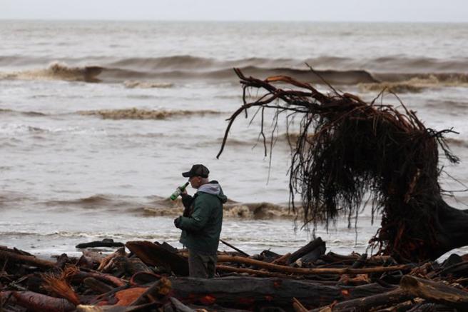 元旦过后的第一周，圣克鲁斯郡的卡皮托拉镇（Capitola）有座码头上的木桥遭疾风破坏断裂成两半，当地海滩放眼望去满是断木。（图/ 路透社）