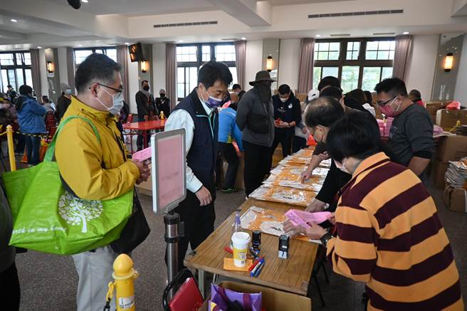 报名信眾领取臂章、进香服等物品。（李京升摄）