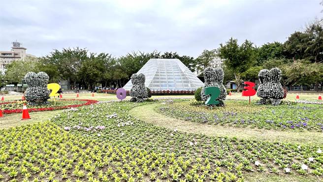 市府运用6万株花草在新营南瀛绿都心公园中央草坪区打造了大片的疗癒花海，并设计了4只身穿黄、紫、绿、红色花衣的小白兔跳跃其中。（张毓翎摄）