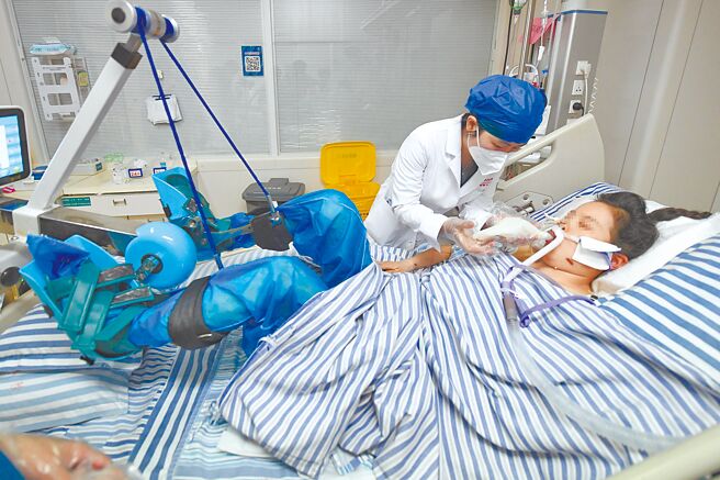 大陸公布去年12月8日至今年1月12日的在院死亡病例後，WHO發布聲明，對中國發布新資訊表示歡迎。圖為湖南的中南大學湘雅醫院醫護為新冠患者進行康復訓練。（中新社）