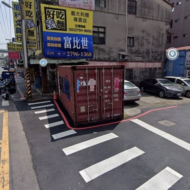 台北内湖一处道路的斑马线被发现一部分被大型货柜「压着」，斑马线因此变得长短不一，影响路人行走，连一旁的红线都沿着货柜周围划设。（翻摄自脸书「爆废公社」）