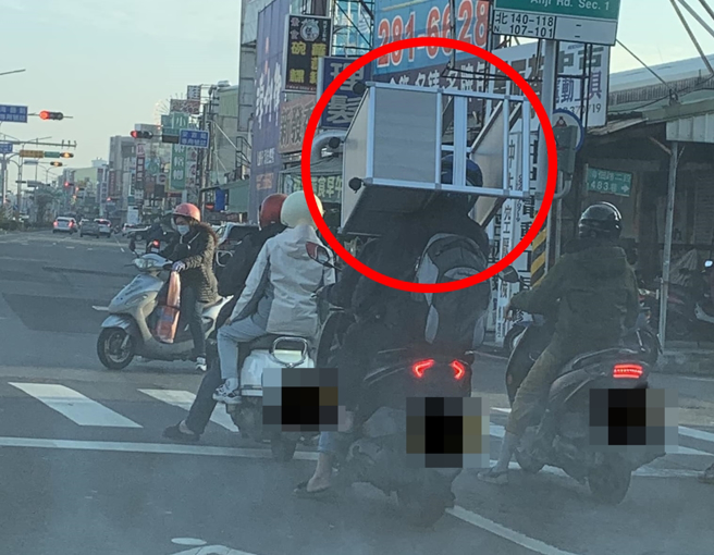 台南街头竟发现有双载骑士竟把桌子卡在脖子上运送，这夸张的行为也让网友看傻眼。（翻摄自脸书路上观察学院）
