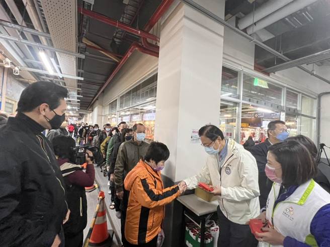 桃园市长张善政17日到新永和市场发福袋，民眾排队抢拿，他也逐一关心摊商。(蔡依珍摄)