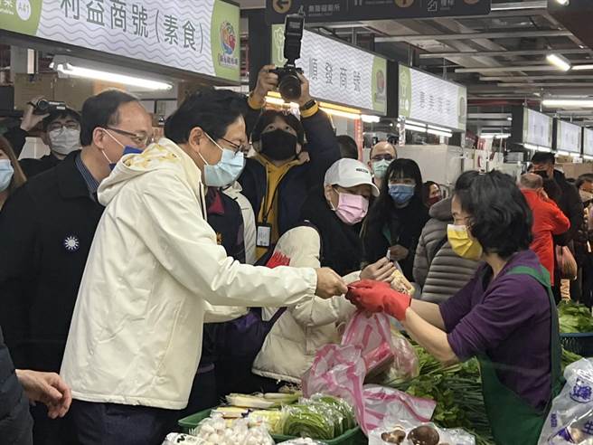 桃园市长张善政17日到新永和市场发福袋，民眾排队抢拿，他也逐一关心摊商。(蔡依珍摄)