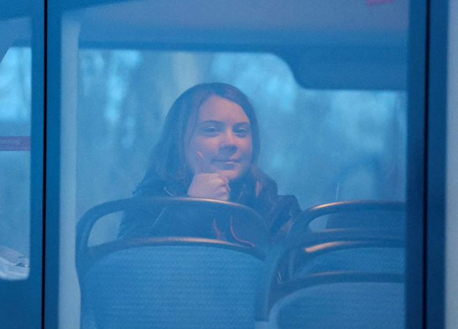 环保少女童贝里（Greta Thunberg）17日在德国矿场抗议时被警察扛走逮捕，她坐上警车后对着媒体露出笑容比讚。（图／路透社）