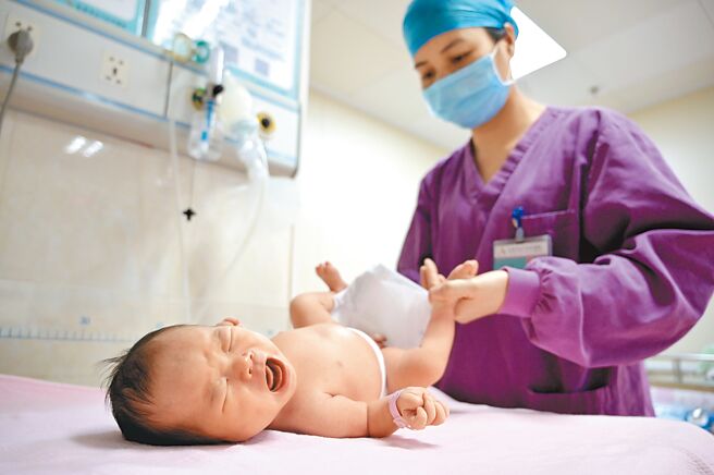 大陸國家統計局17日發布2022年國民經濟運行數據，驚見總人口出現近61年首次負成長。圖為廣西南寧市紅十字會醫院內，助產士為新生兒進行體檢。（中新社）