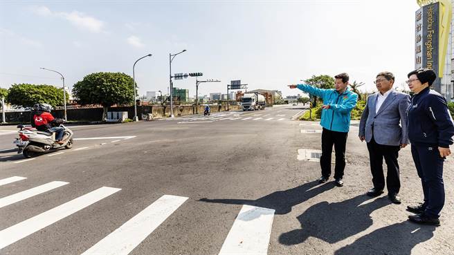 县府工务处长江良渊（左）向县长杨文科（中）说明荣光路拓宽后在凤山工业区前路口增加左转专用道和设储车道，能有效疏解上下班车潮。（罗浚滨摄）