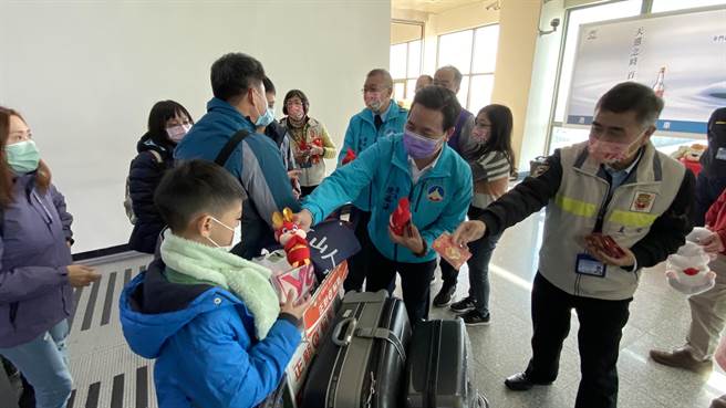 金门县长陈福海(右2)与航空站主任洪念慈(右1)一同迎接民眾返乡，并发给大家讨喜礼物贺新年。(于家麒摄)