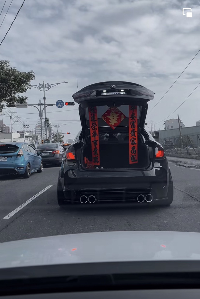 一辆BMW X6突然左切至轿车前方后开启「电尾门」，后车厢缓缓打开后竟是2条春联被拉开。（翻摄自脸书「Drive 7867 Life」）