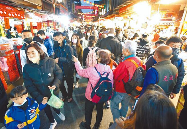今年年节食品买气强强滚，芥菜（长年菜）价格和去年相比，约涨了3成5，为涨幅最大的春节必备食品。图为迪化街年货大街内，大批民眾正在採购年货。（范扬光摄）