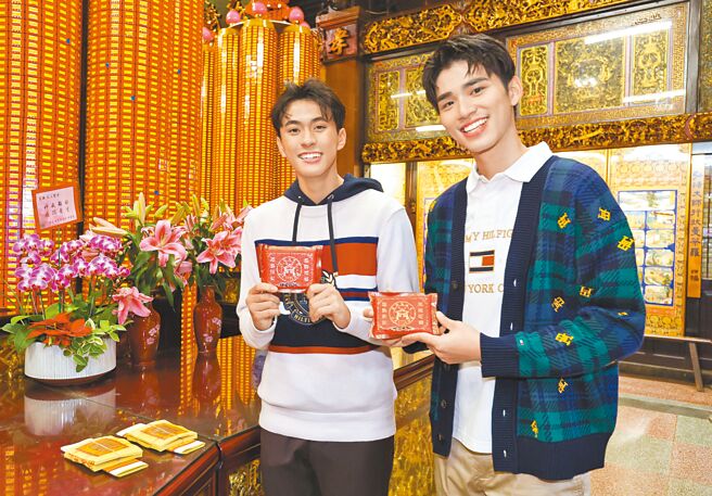 王品澔（右）、徐玮泽完成安太岁、点光明灯及拜拜仪式后，开心拿着庙方平安米保平安。（陈俊吉摄‧服装提供：Tommy Hilfiger）