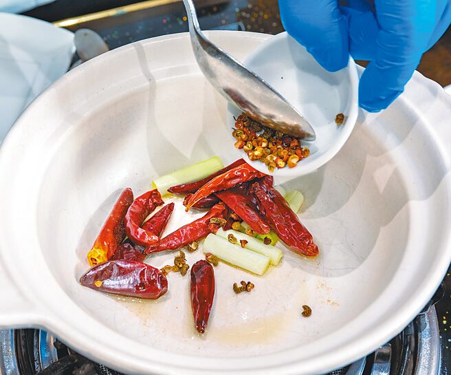 步骤1.锅内放入少许花椒油，依序爆香葱段、乾辣椒、花椒粒