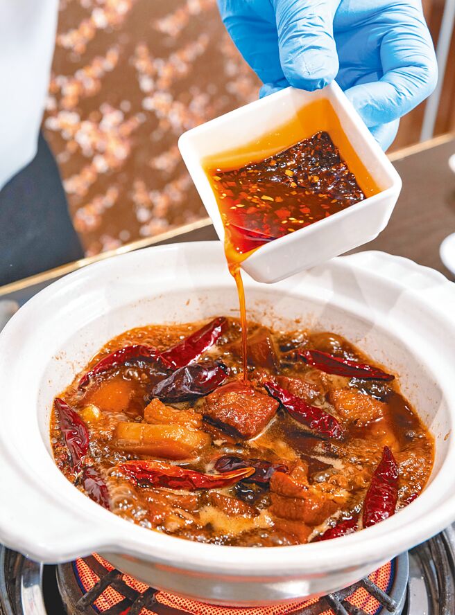 3.依个人口味加入辣油调味，盛盘前加入葱段增色，倒入砂锅端上桌