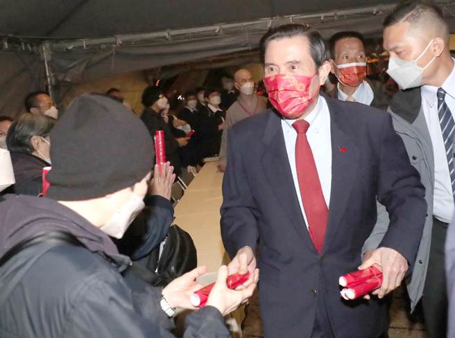 法鼓山21日于除夕夜举办「除夕撞钟祈福法会」，前总统马英九（左）出席法会之后，亲自赠送现场民眾兔年的春联。（郑任南摄）