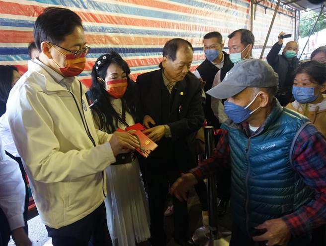 张善政与夫人张琦雅向在场信眾发放福袋。(杨宗灏摄)