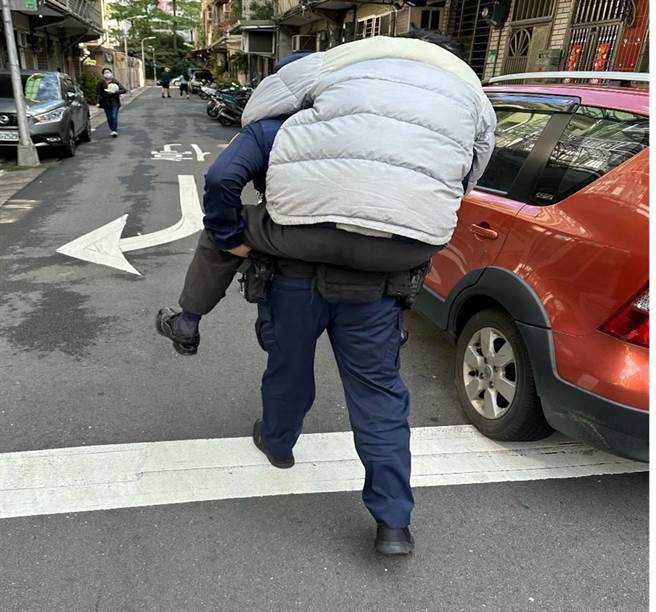 巡逻员警背负91岁行动不便的老翁返回住处。（翻摄画面）