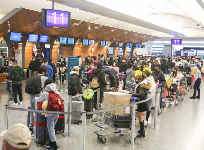 國內疫情趨緩，民眾趁著春節連假出國旅遊，讓桃機出境大廳排滿辦理登機手續的人潮。（陳麒全攝）