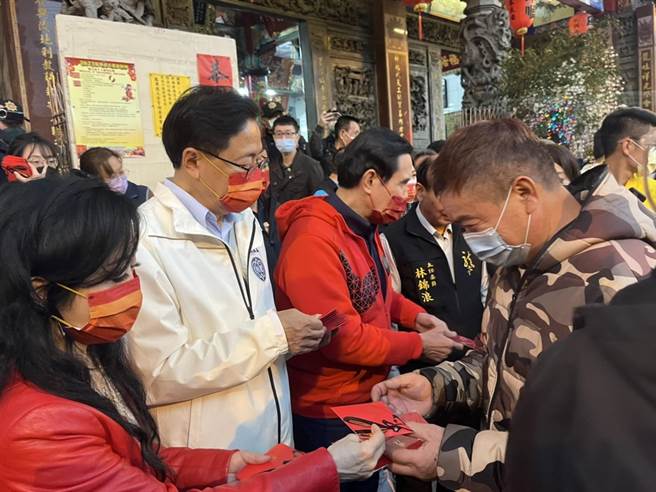 前总统马英九、桃园市长张善政两人在龙潭龙元宫合体，共同发放新春福袋给民眾。（陈梦茹摄）