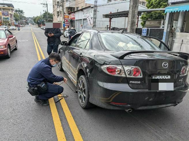 一只狗遭卷入车底哀嚎求救，警方以千斤顶将受困小狗救出。（警方提供）