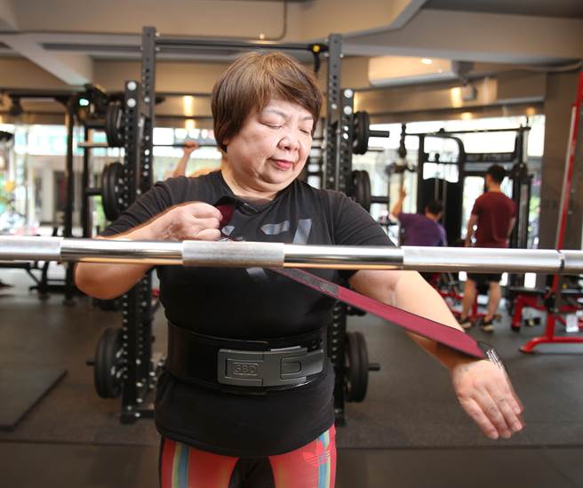 今年61歲外號「健力Q嬤」健力選手李彩薇（見圖）練習前仔細穿戴護具。（陳怡誠攝)