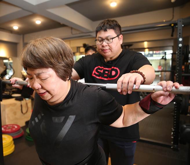 教練兒子楊孟穎（後）訓練時，細心照顧母親李彩薇（前）動作，讓她從事健力運動上沒受過傷。（陳怡誠攝)