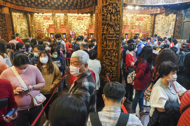 过年期间，各寺庙挤满人潮，奉天宫内受理安太岁柜台前信徒大排长龙。（黄子明摄）