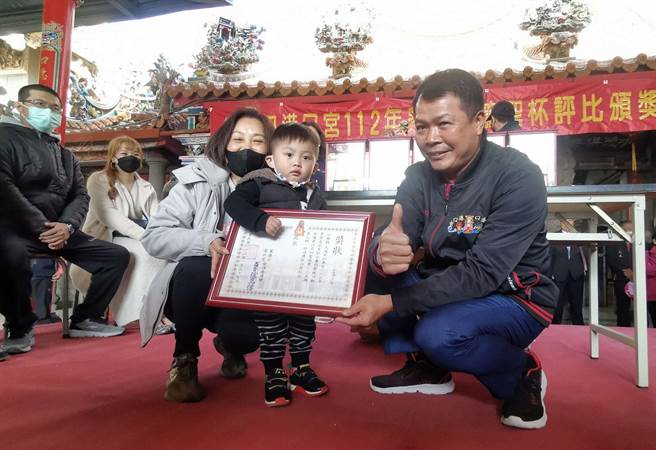 吳姓小男童擲筊拿到新機車，跟阿嬤一起高興領獎。（廖素慧攝）