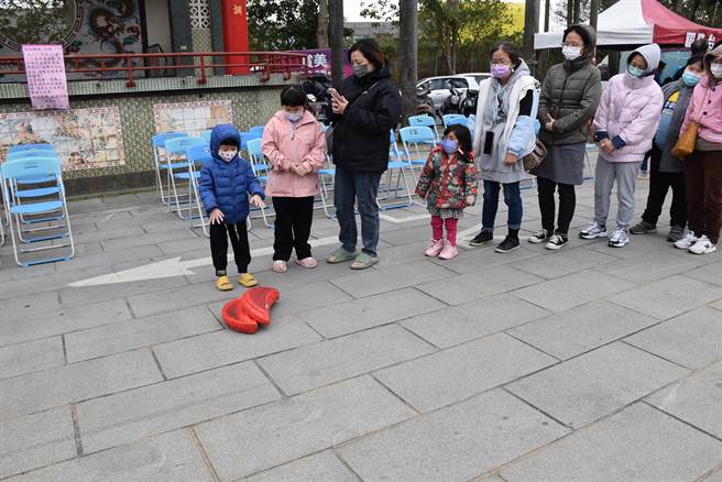 苗栗（火旁）龙系列活动27日正式在头份市永贞宫登场，小朋友掷筊换福袋。（谢明俊摄）