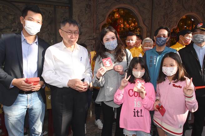 民眾得知民眾党主席柯文哲（左二）27日到左营新庄仔天公庙发放发财金，带着孩子到场排队领发财金并与柯文哲合影。（林瑞益摄）