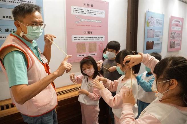 「衣起玩艋舺」特展中志工老师指导小朋友认识捻线。（北市乡土教育中心提供／张芷瑜台北传真）