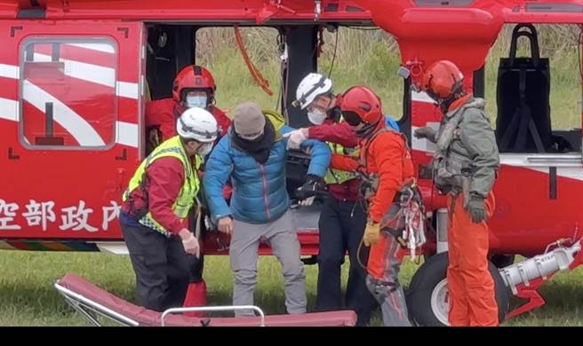 空勤总队花莲驻地直升机今天出动，将摔落边坡受伤的杨姓山友（左二）救下山送医。（花莲县消防局提供）