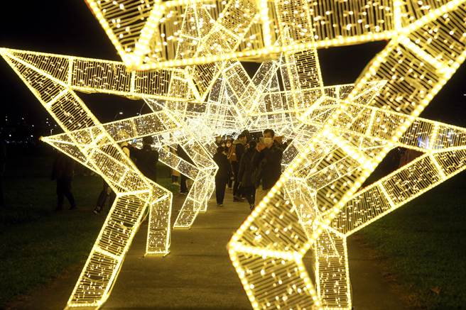 2023新北燈會26日開幕，「迎賓光環境燈區」以星星造型燈飾迎接民眾走入燈會，一整排的星星長廊吸引民眾駐足拍照。（黃世麒攝）