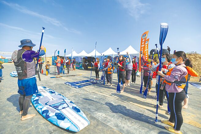 游客报名SUP免费体验活动相当踊跃，SUP教练在猫罗溪畔手把手教学。（南投县政府提供／杨静茹南投传真）