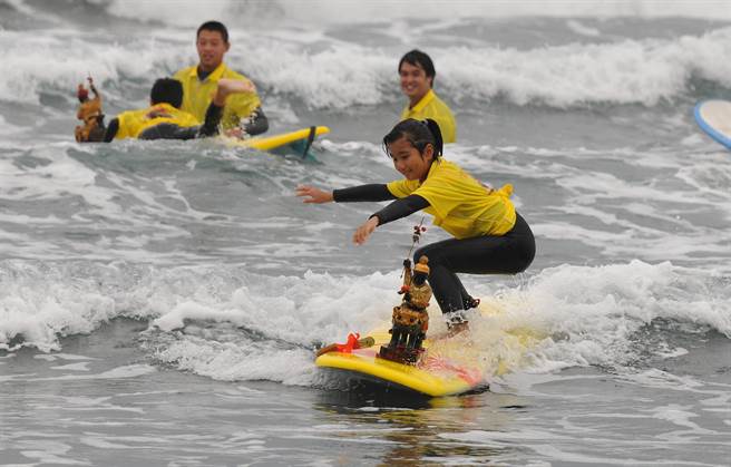 宜兰县大溪国小学生与外澳庆天公的神尊一同下海衝浪，玩的不亦乐乎。（庆天公顾问吴杨钦提供／吴佩蓉宜兰传真）
