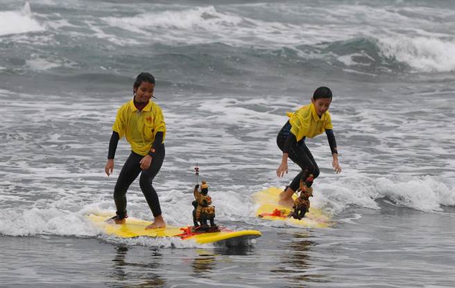 宜兰县学生与外澳庆天公的神尊一同下海衝浪，玩的不亦乐乎。（庆天公顾问吴杨钦提供／吴佩蓉宜兰传真）