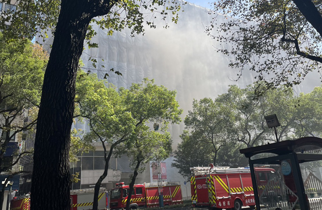 原国宾饭店工地，今午冒出白烟，消防车到场协助。（何立雯摄）