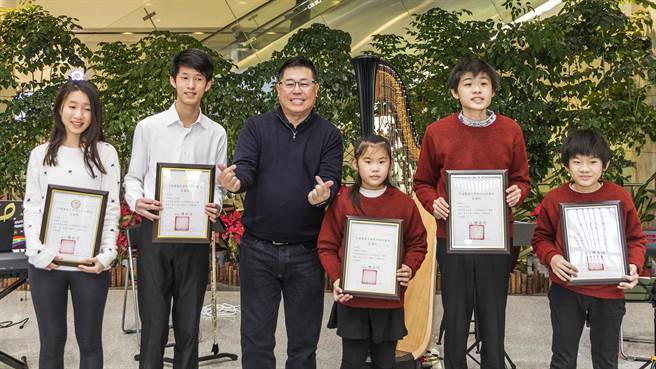 中医大新竹附医兔年迎新举办音乐飨宴，院长陈自谅（中）颁奖感谢5位音乐志工学生。（罗浚滨摄）