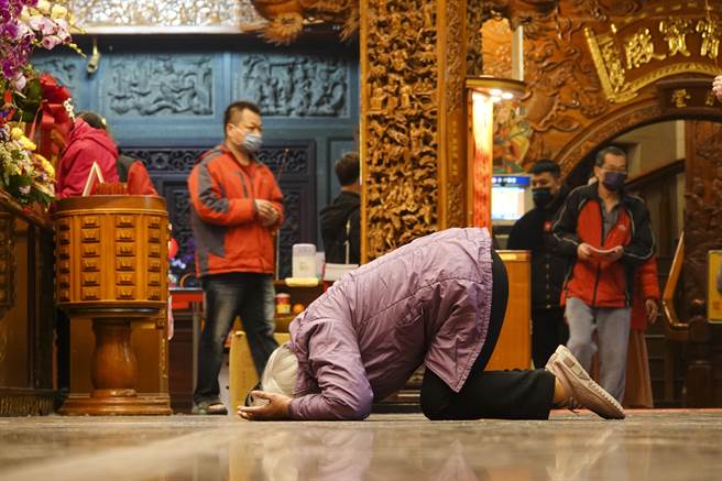 台北市松山奉天宫在农历正月初九天公生吸引许多信眾前往参拜，一名妇女俯身在地板上跪拜。（黄子明摄）