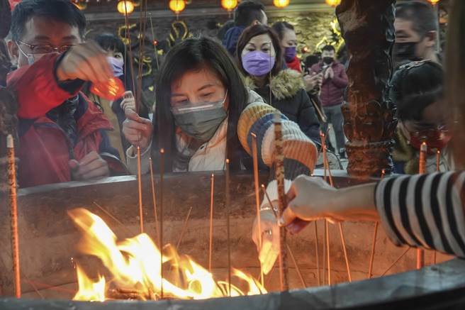 许多民眾在农历正月初九前往台北市松山奉天宫拜天公，一名女子拿着个人物品过炉祈求平安。（黄子明摄）