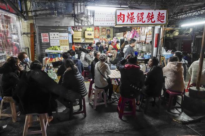 台北市松山奉天宫30日涌入许多信眾拜天公，路口小吃店在深夜时刻依旧大排长龙。（黄子明摄）