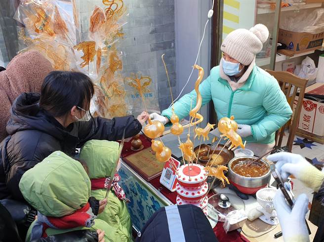 北京宣布：重点商圈将开展外摆试点，经营者向所在街道网上报备。图为前门大街商圈在春节期间的小摊贩。（蓝孝威摄）