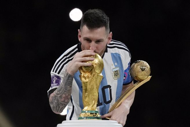 阿根廷前鋒梅西親吻世足冠軍盃。（美聯社資料照）
