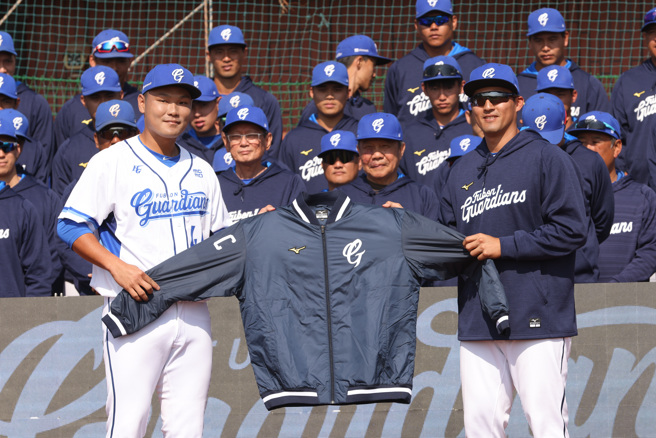 富邦悍將新隊長范國宸（左），從前隊長林哲瑄手中接下右臂繡上代表隊長的「C」字外套。（富邦悍將提供）