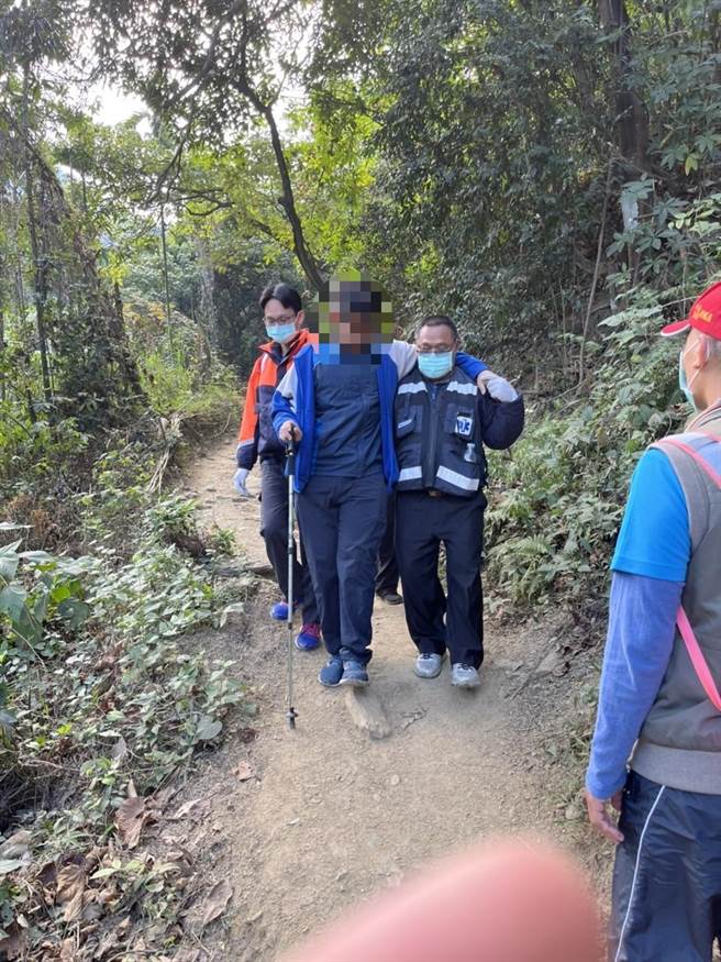 独攀笠顶山体力不支，警消以搀扶方式协助男子下山。(屏县消防局提供)