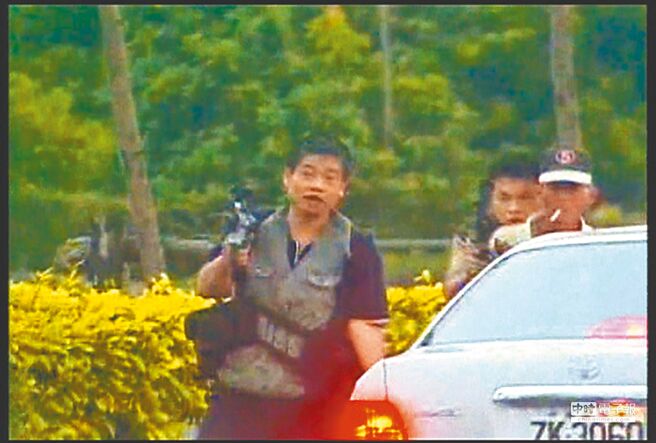 被判无期徒刑的张锡铭（左一），至今申请18次假释均失败。图为他2004年与同伙被围捕时，挟持1名老农（右一），但老农反应淡定，更趁警匪驳火时顺利脱险。（本报资料照片）