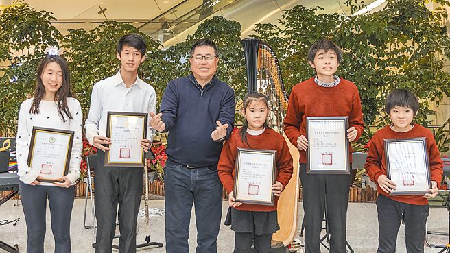 中医大新竹附医兔年迎新举办音乐飨宴，院长陈自谅（右四）颁奖感谢5位音乐志工学生。（罗浚滨摄）