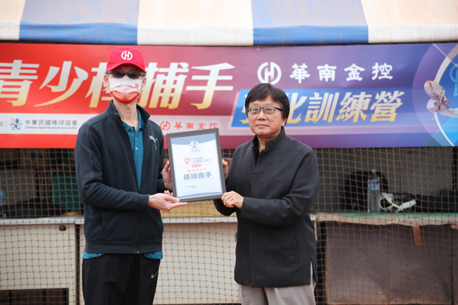 中华民国棒球协会秘书长林宗成（右）致赠感谢状给多年协助推动基层棒球培训的华南金控，由华南金控处长陈伯壎（左）代表接受。（中华民国棒球协会提供）